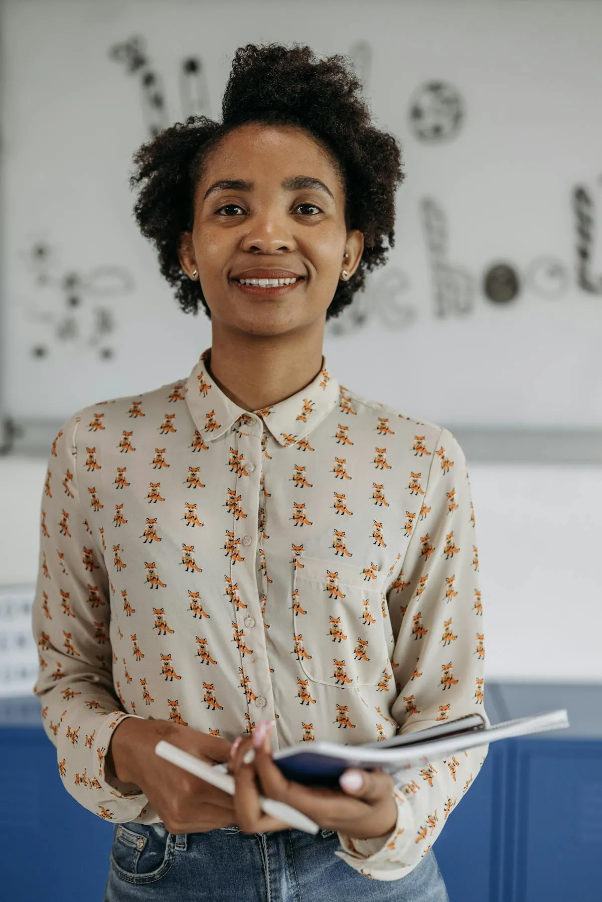 Lachende docent met een notitieblok voor de klas